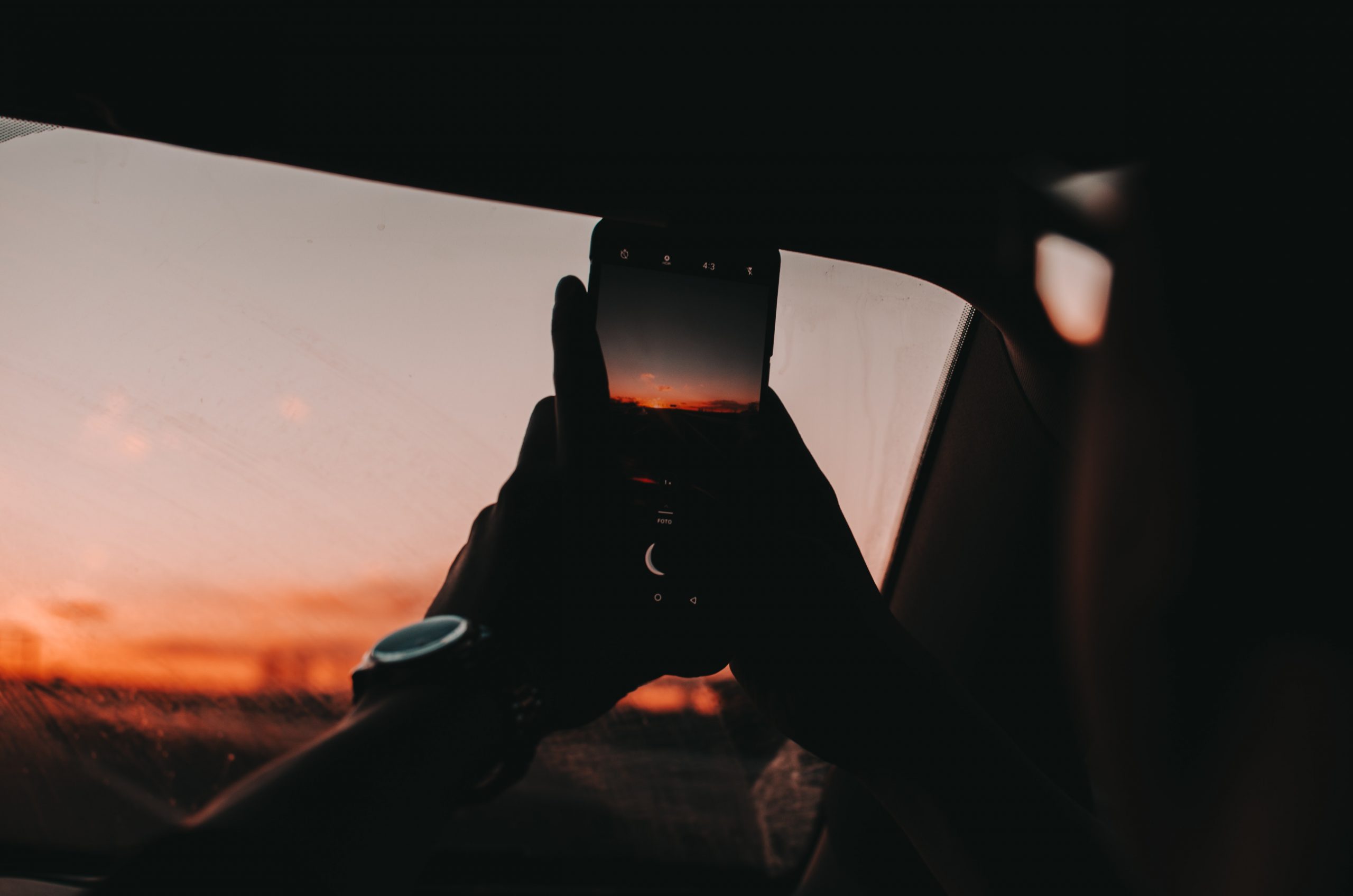 Ein Smartphone fotografiert einen Sonnenuntergang